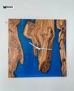 Orologio da parete di design realizzato in legno massello di ulivo secolare immerso in resina blu oceano