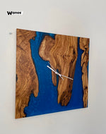 Orologio da parete di design realizzato in legno massello di ulivo secolare immerso in resina blu oceano