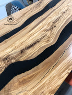 Tavolo di design con piano in legno massello di ulivo secolare immerso in resina nera su struttura in ferro