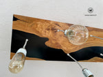 Lampadario realizzato in legno massello di ulivo secolare immerso in resina epossica nera con sei punti luce