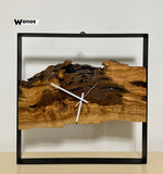 Orologio da parete di design realizzato in legno massello di ulivo secolare su struttura in metallo .
