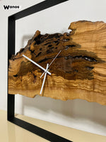 Orologio da parete di design realizzato in legno massello di ulivo secolare su struttura in metallo .