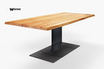 Tavolo di design con piano in legno massello di castagno scortecciato su struttura in metallo nero opaco allungabile