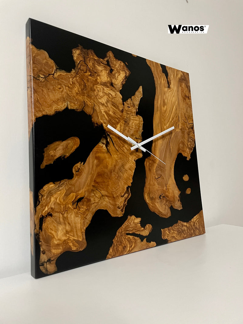 Design wall clock made of centuries-old olive briar immersed in black resin