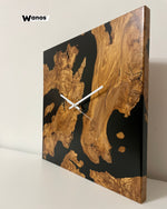 Design wall clock made of centuries-old olive briar immersed in black resin