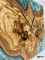Design wall clock made of solid centuries-old olive wood immersed in green marbled resin