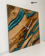 Design wall clock made of solid chestnut wood immersed in marbled blue resin