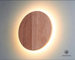 Circular wall light made of solid chestnut wood with integrated LED light