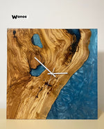 Design wall clock made of solid centuries-old olive wood immersed in aquamarine colored resin