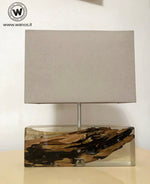 Lampada da tavolo di design realizzata con legno marino immerso in resina trasparente.