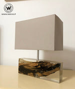 Lampada da tavolo di design realizzata con legno marino immerso in resina trasparente.