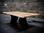 Design table in solid natural chestnut wood on a metal base with an irregular edge